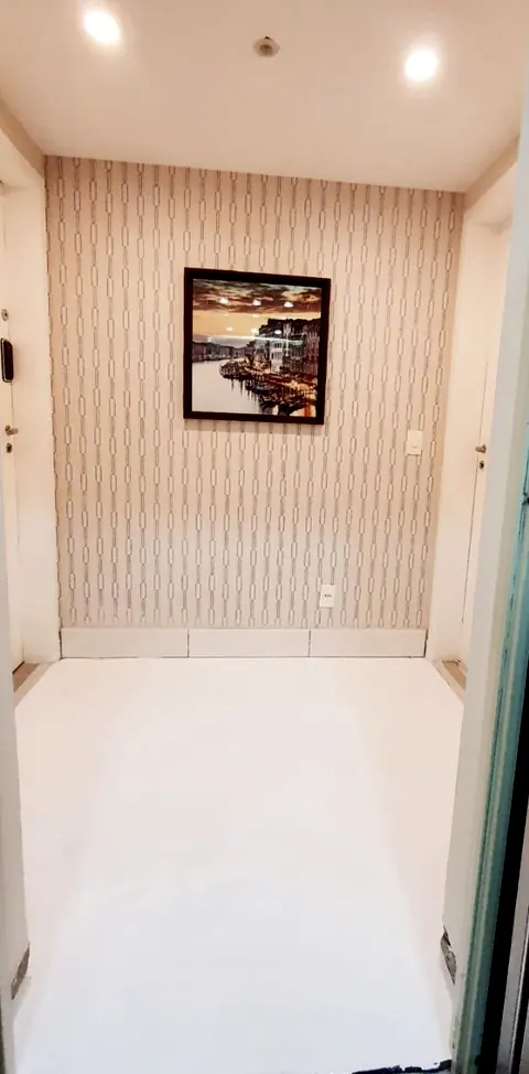 Antes: hall de entrada com papel de parede listrado e piso branco
