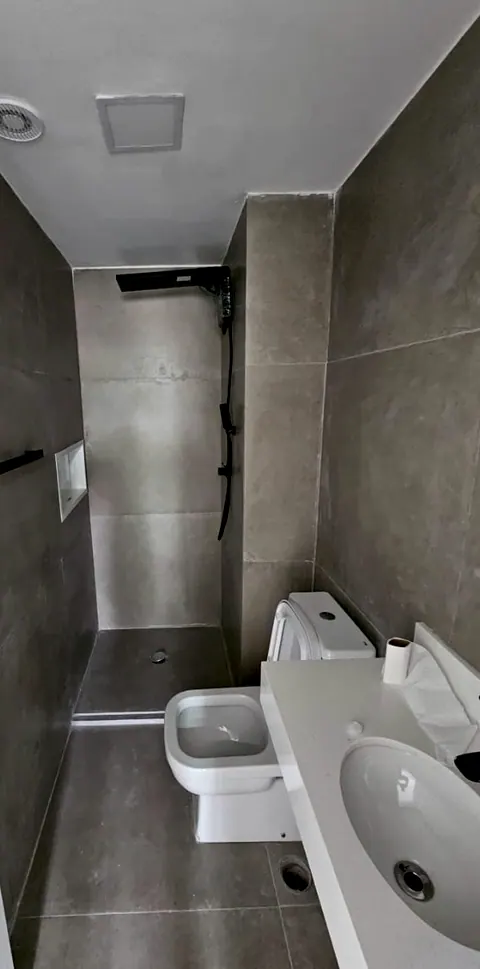 Depois: banheiro com porcelanato cinza nas paredes e no piso