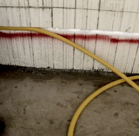 Eletroduto amarelo no chão da obra, junto da parede
