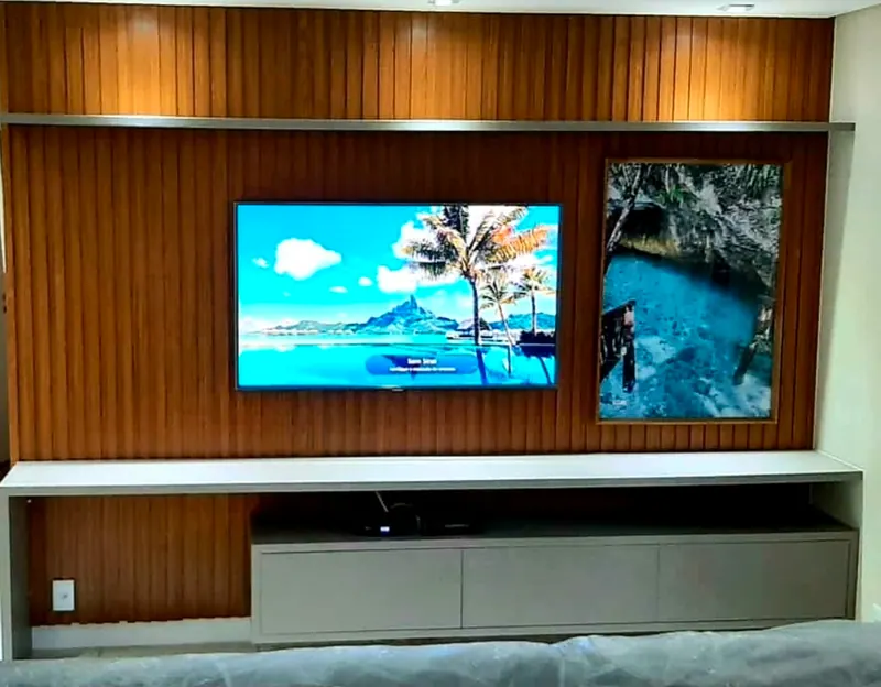 Painel de madeira com TV, nicho de quadro e rack bege embaixo