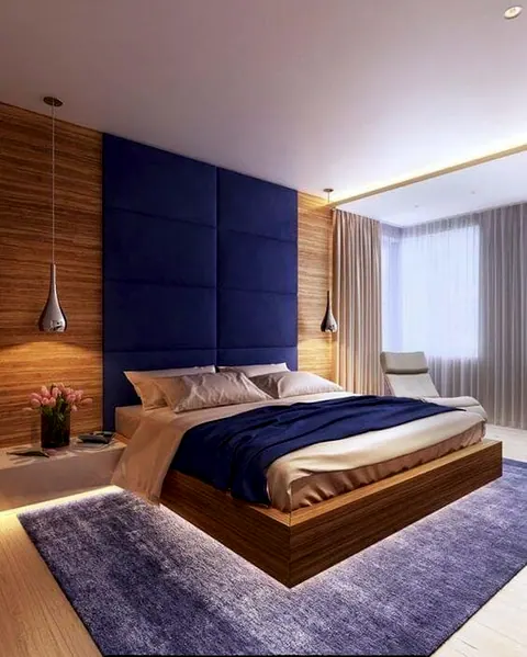 Projeto de quarto com cabeceira azul estofada e parede de madeira